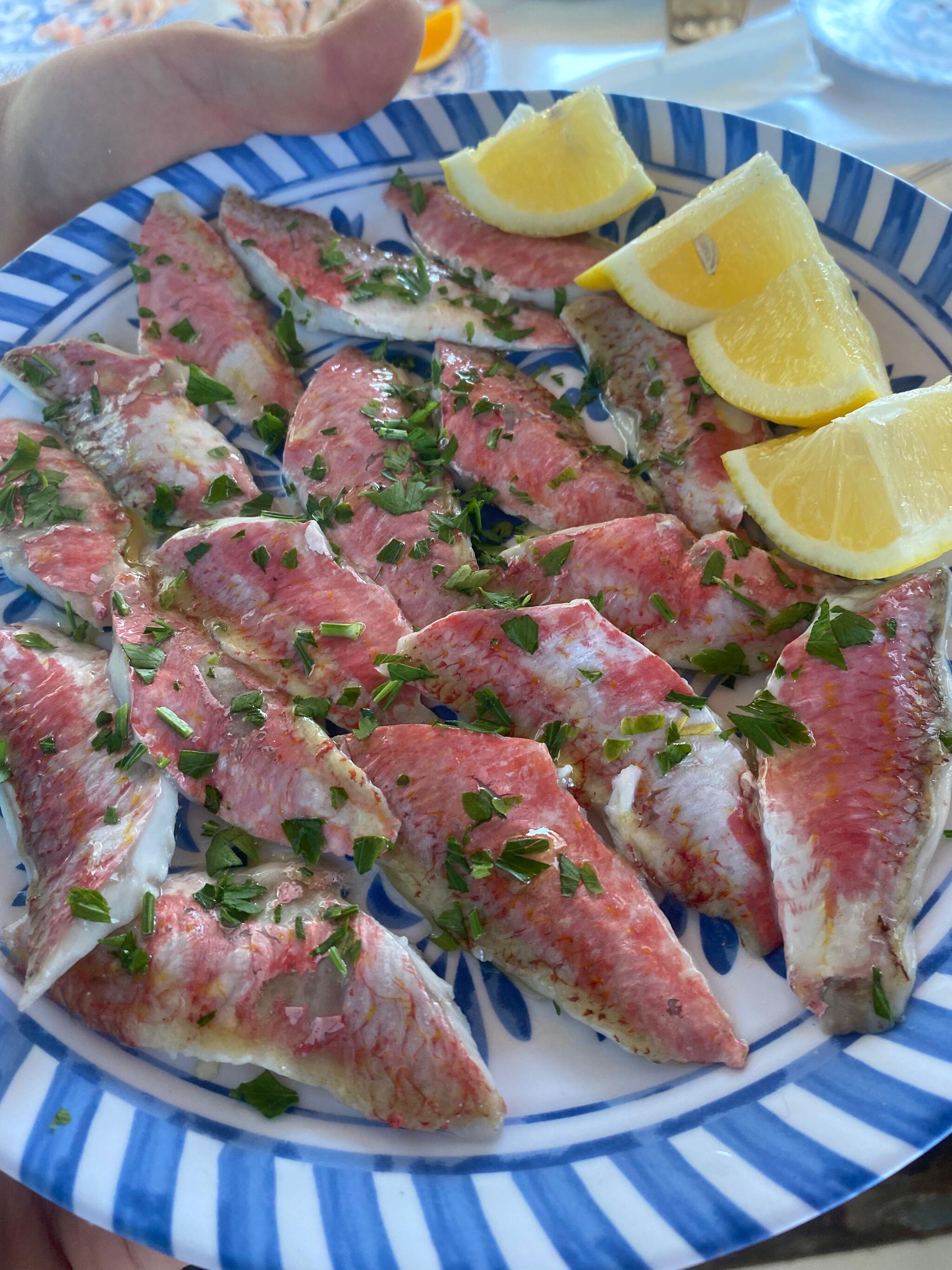 Plate of raw fish with lemon prepared on board